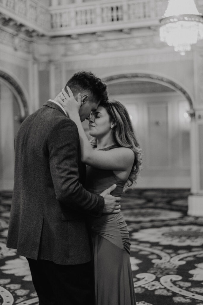couple slow dancing under chandelier in hall of doges at davenport hotel