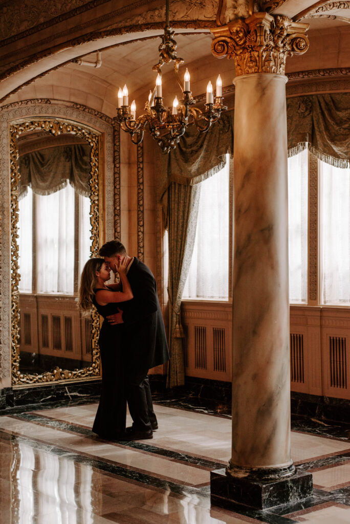 couple slow dancing under chandelier in isabella ballroom in davenport hotel