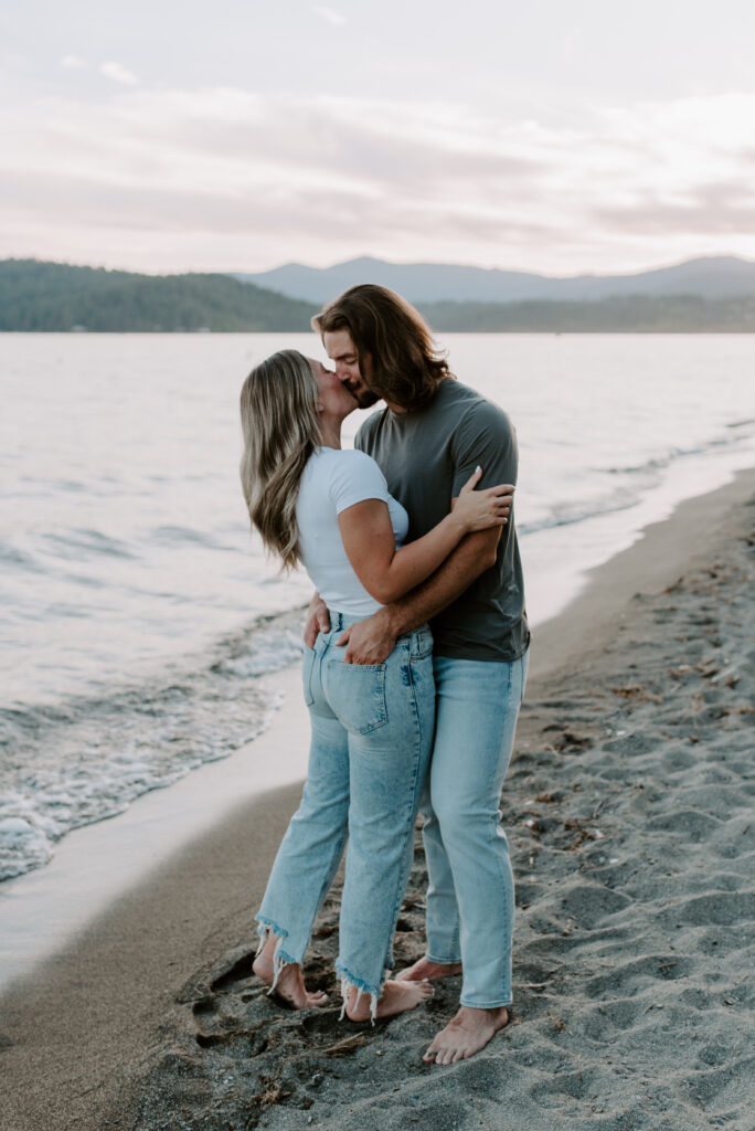 engaged couple kissing on the beach at Coeur D'Alene Idaho