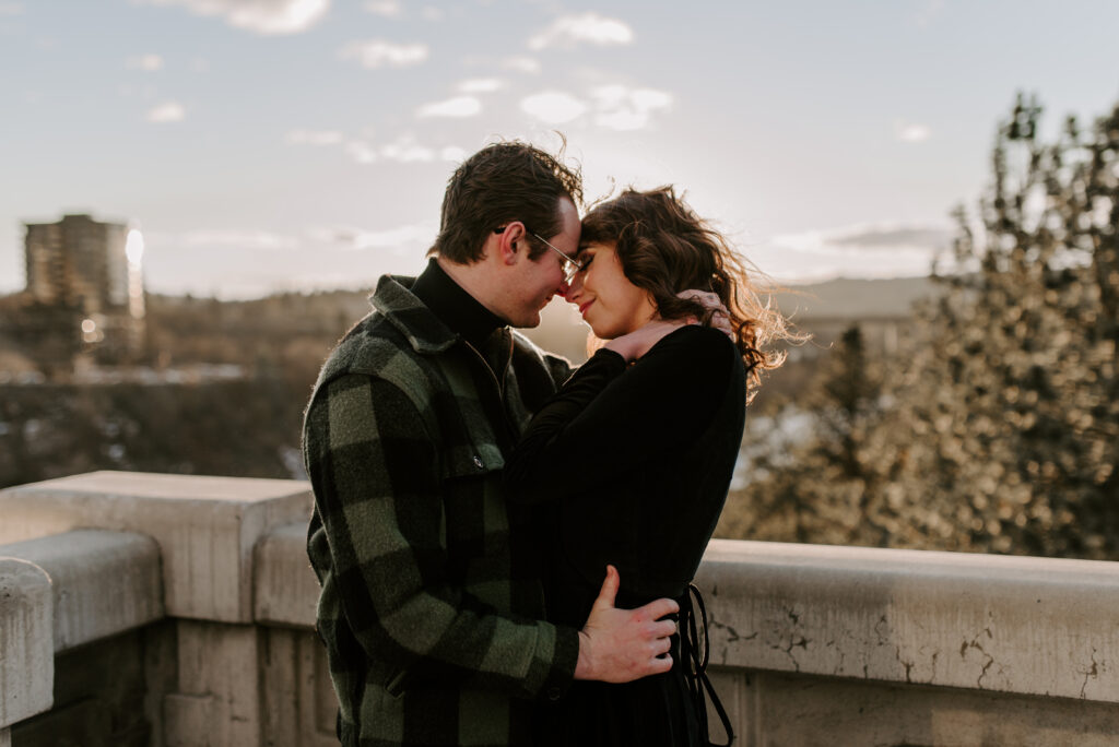 engaged couple standing on a bridge in Spokane Washington