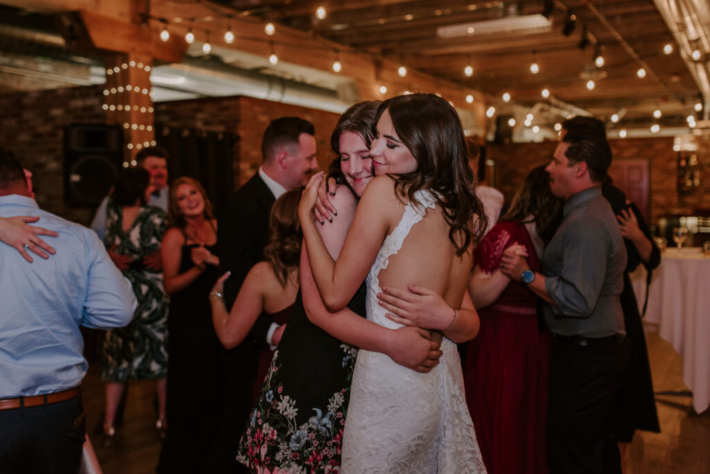 bride hugging a friend on the dance floor