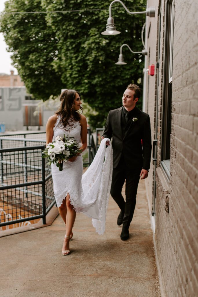 Bride and groom walking together in front of The Boxcar Room