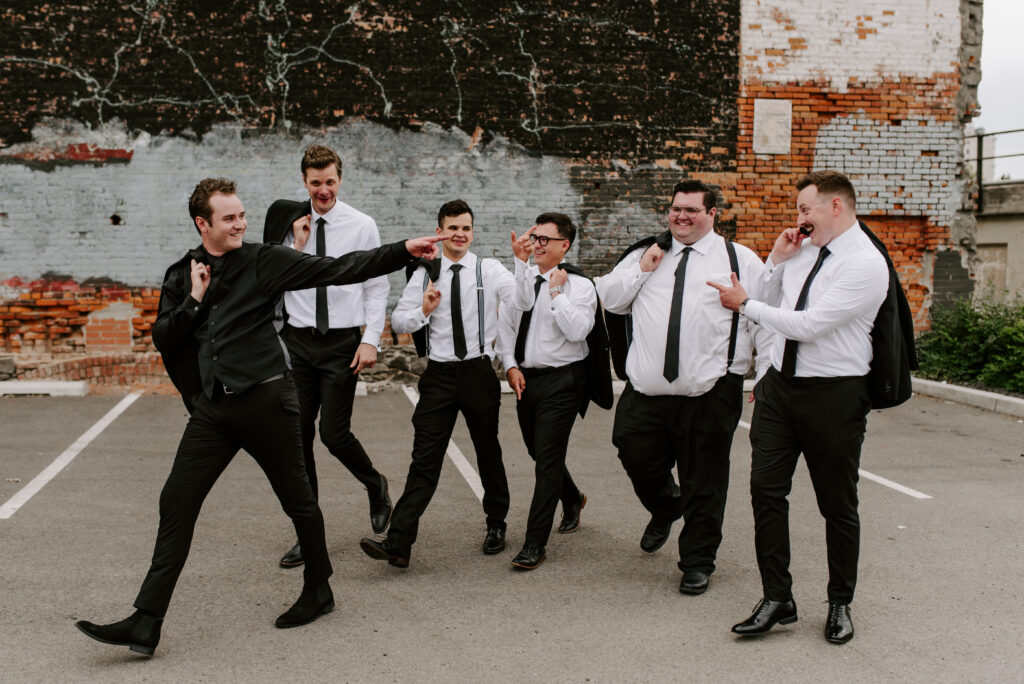 Groomsmen walking with the groom and laughing
