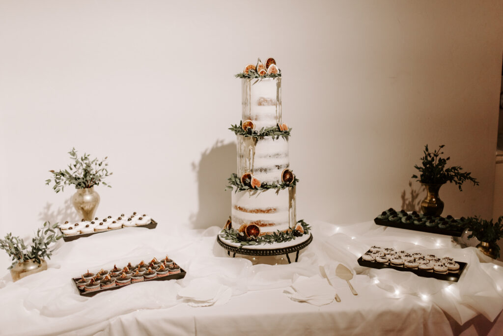 Custom wedding cake with dessert at dessert table