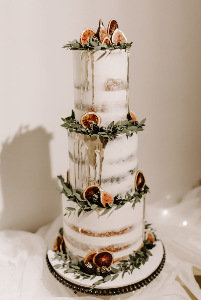 custom wedding cake with dried oranges and gold accents