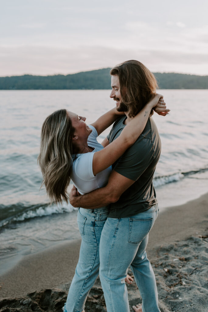 Couple on the beach for engagement photos at Lake Coeur D'Alene