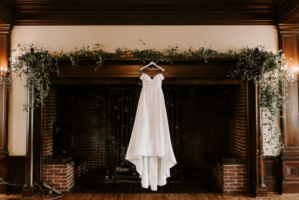 Bride's wedding dress hanging on mantle