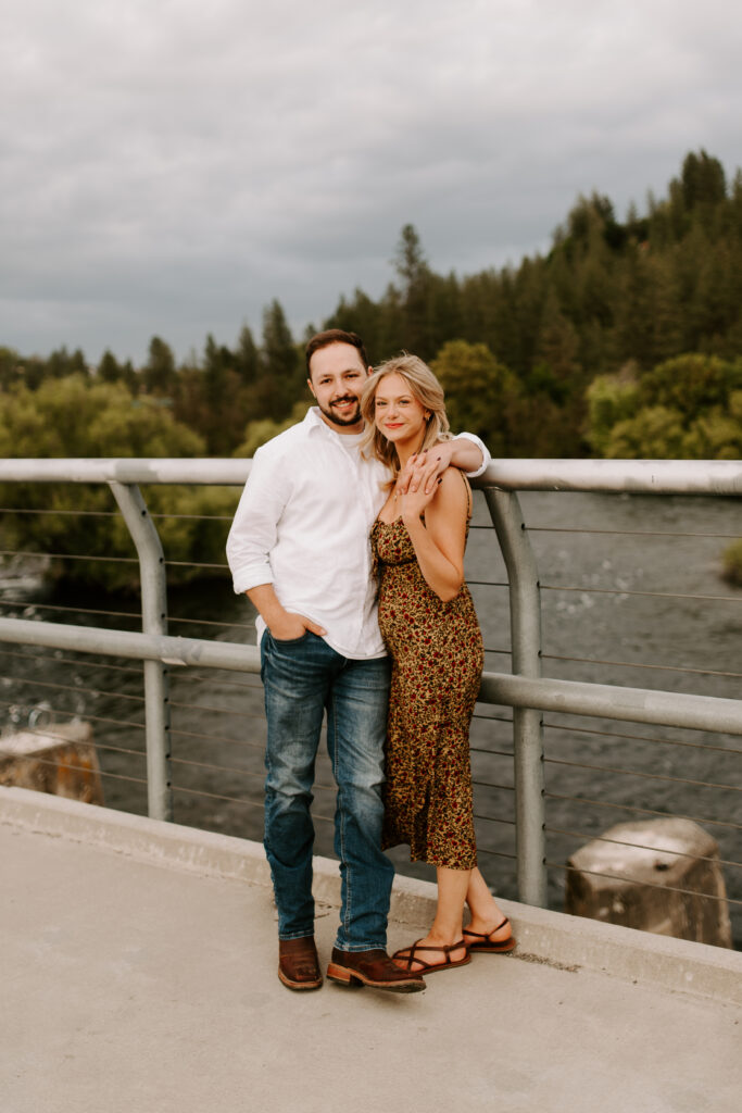 future bride and groom standing on bridge