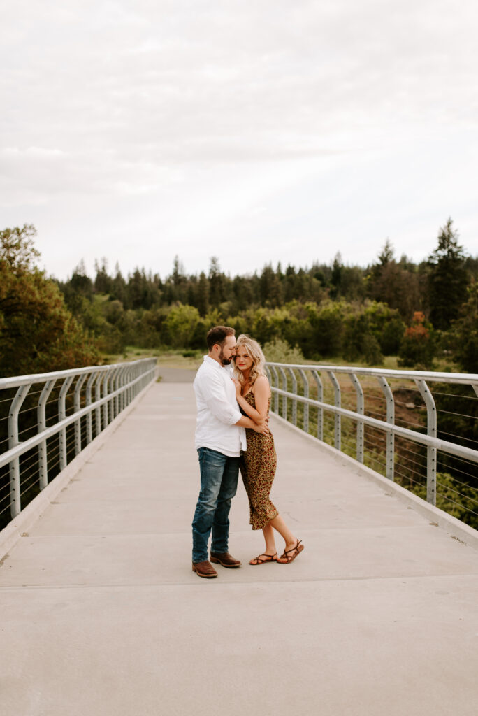 future bride and groom standing on bridge