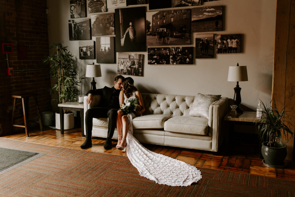 Bride and Groom sitting on a couch in the front room in The Boxcar Room