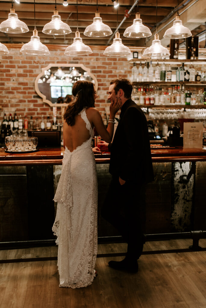 Bride and Groom standing at the bar in The Boxcar Room