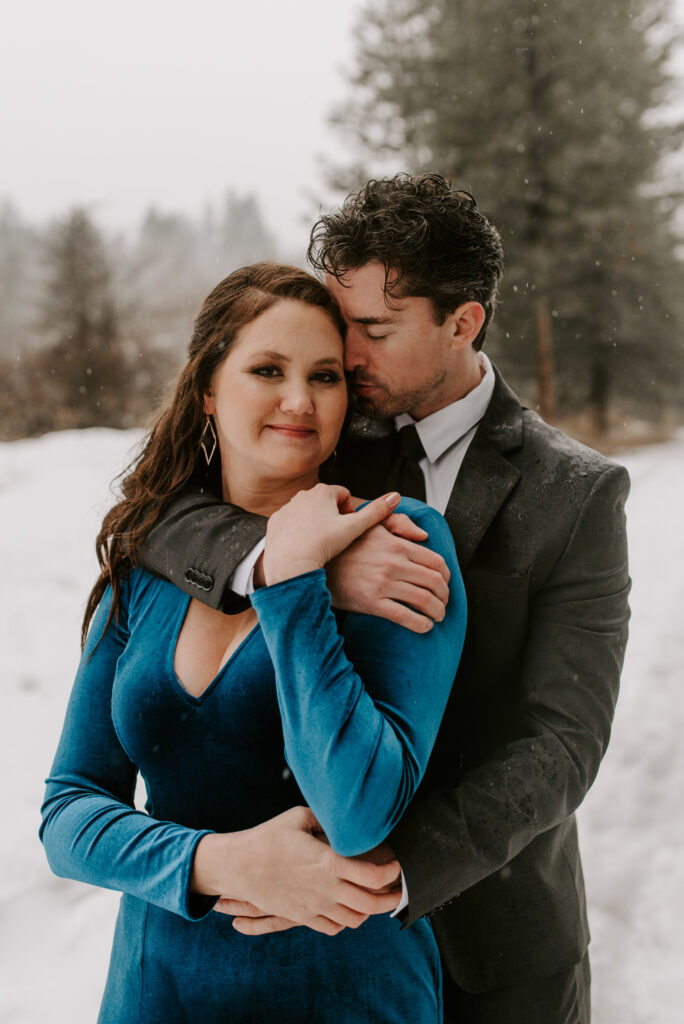 A future bride and groom snuggling together during their winter photos.