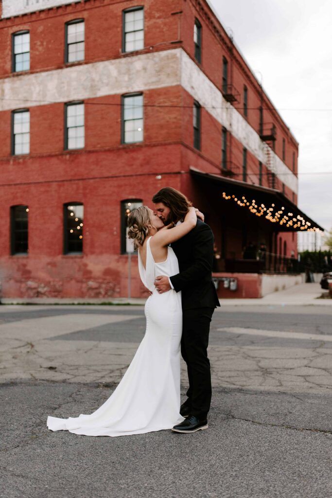 Bride and Groom kissing across the street from their wedding venue.